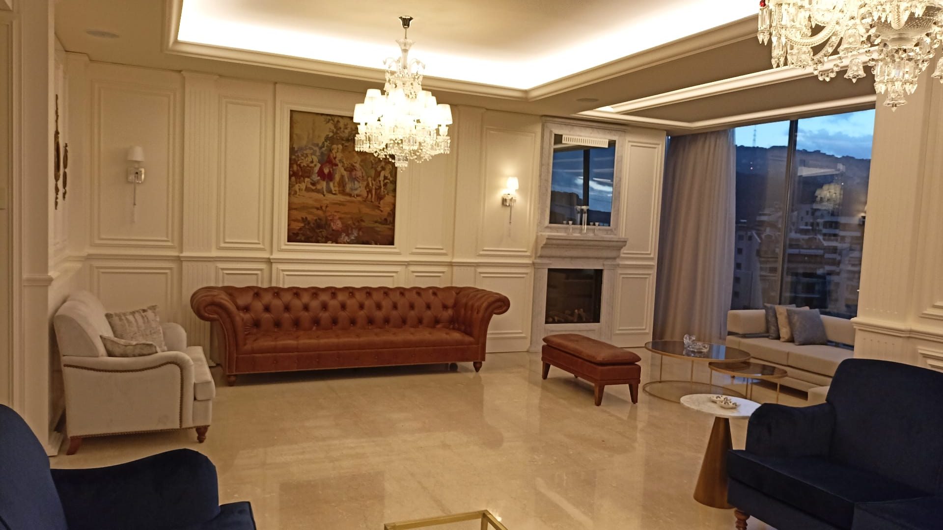 Rabieh apartment: panelled salon with chandeliers and a chesterfield sofa