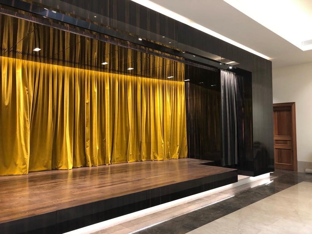 Private theatre stage with gold curtain and dark timber panelling